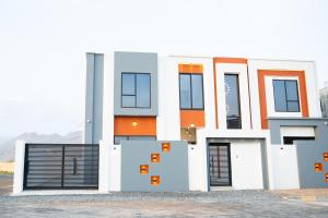 a house with an orange and white facade at Horizon Stay Nizwa in Firq