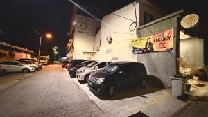 a row of parked cars parked next to a building at Near Jonker Street - JCITYHOTEL - FREE PARKING in Malacca