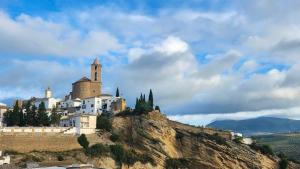 a castle on a hill with a church on it at Casa del Delfin in Iznájar