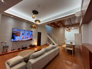 a living room with a large couch and a tv at White in Gukeng