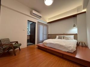a bedroom with a bed and a chair in it at White in Gukeng