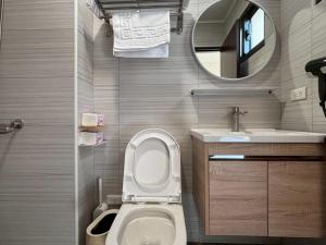 a bathroom with a toilet and a sink and a mirror at White in Gukeng +25 photos