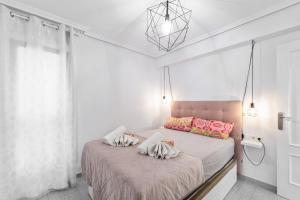 a bedroom with a bed with two pillows on it at Mar y Sol in Torrevieja