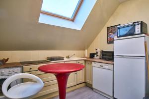 a red stool in a kitchen with a white refrigerator at La Matheysiene in La Motte-dʼAveillans