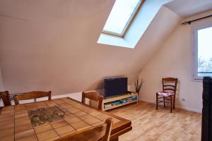 a living room with a table and a tv at La Matheysiene in La Motte-dʼAveillans