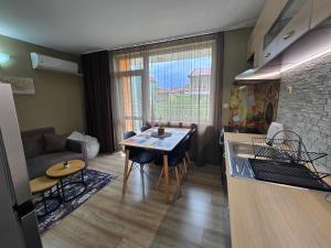 a kitchen and living room with a table and a couch at Квартири СЪН in Nesebar