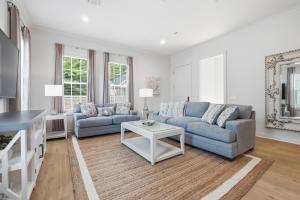 a living room with two blue couches and a table at Spacious 3BR - Pool - Beach Nearby in Pass Christian