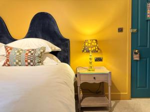 a bedroom with a bed and a table with a lamp at East Beach Guest House in Littlehampton