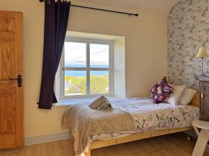 a bedroom with a bed and a window at Cottage 507 - Renvyle in Renvyle
