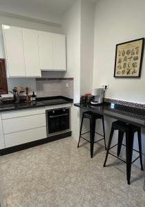 a kitchen with white cabinets and a black counter top at Casa del Delfin in Iznájar