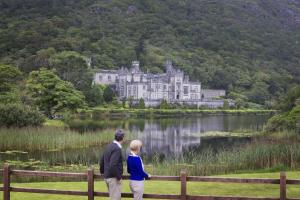 a man and a woman standing in front of a castle at Cottage 507 - Renvyle in Renvyle