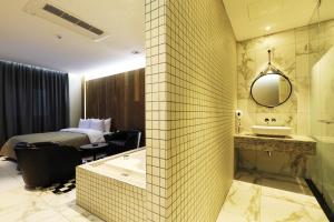 a hotel room with a bathroom with a tub and a bed at Cheonan La Tree Hotel in Cheonan