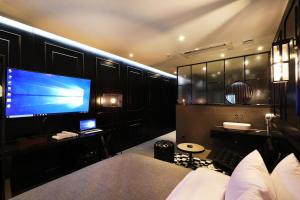 a bedroom with a large screen tv and a bed at Cheonan La Tree Hotel in Cheonan