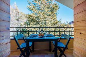 a table with chairs and a bowl of fruit on a balcony at CHALET LAURA apricacasevacanze in Aprica