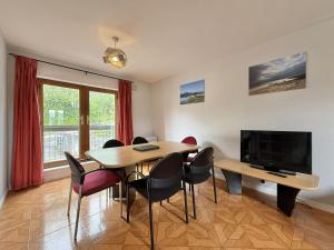 a dining room with a table and chairs and a television at Apartment 514 - Clifden in Clifden