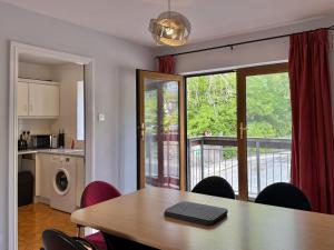 a kitchen and dining room with a table and a balcony at Apartment 514 - Clifden in Clifden