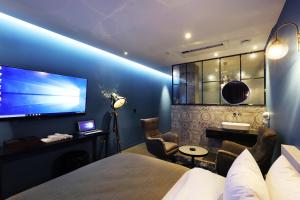 a hotel room with a bed and a large screen television at Cheonan La Tree Hotel in Cheonan