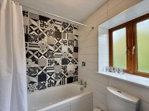 a bathroom with a white tub and a toilet and a window at Apartment 514 - Clifden in Clifden +28 photos