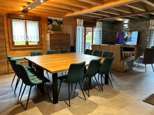 a dining room with a wooden table and green chairs at Chalet Heidi in Ventron