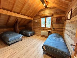 a bedroom with two beds in a log cabin at Chalet Heidi in Ventron