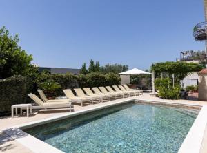 a swimming pool with lounge chairs and a swimming pool at Marghareta Nest 2 - TOP Location in Dubrovnik