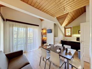 a dining room and living room with a table and chairs at L'Eterlou by Mountain Collection Immobilier in Saint-Chaffrey