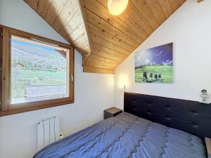 a bedroom with a bed and a large window at L'Eterlou by Mountain Collection Immobilier in Saint-Chaffrey