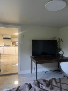 a living room with a table and a television at ocean view two bedroom suite in Oak Bay