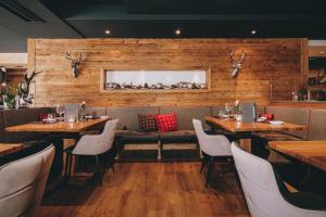 a restaurant with wooden walls and tables and chairs at Hotel Kaprunerhof in Kaprun
