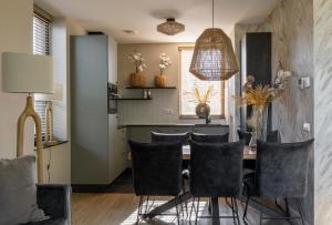 a kitchen and dining room with a table and chairs at Parc La Dune Dutch Lodge in Warmenhuizen