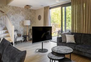 a living room with a large flat screen tv at Parc La Dune Dutch Lodge in Warmenhuizen