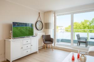 a living room with a tv on a white dresser at Mein-Zingst-Urlaub in Zingst