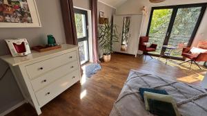 a bedroom with a white dresser and a living room at Dom przy Panke in Kolonie Röntgental