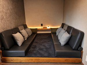 a leather couch in a living room with pillows at Biwako Villa 縁 in Takashima +52 photos