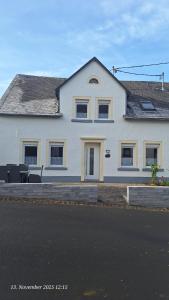 a white house with a table in front of it at Feriendomizil-Vulkaneifel in Hillesheim