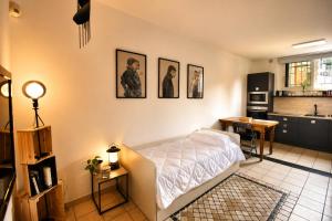 a bedroom with a bed and a table and a kitchen at The Other Side in Lainate