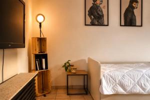 a living room with a bed and a tv at The Other Side in Lainate