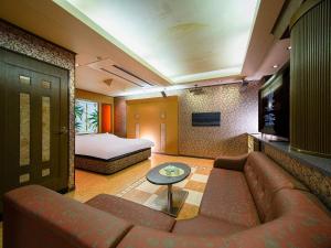 a living room with a couch and a bed at HOTEL WiLL 大高 レジャーホテル in Nagoya