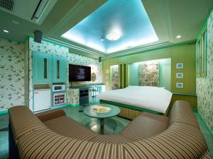 a bedroom with a bed and a couch and a table at HOTEL WiLL 大高 レジャーホテル in Nagoya