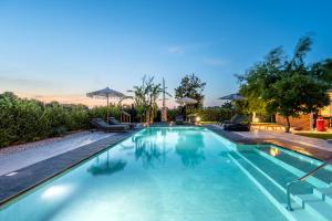 a swimming pool with chairs and umbrellas at The Infinities - Premium Villa Alexandros in Kos