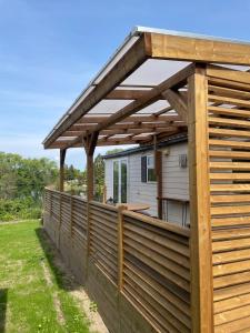 a wooden deck with a pergola on a house at Siblu Prϋβsee in Güster