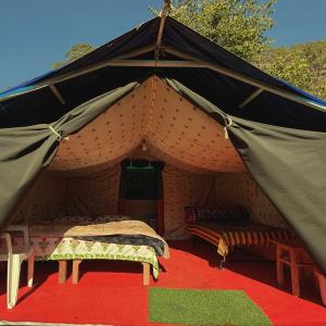 a tent with two beds and a red carpet at Forest Stay - by TripInterval in Nainital
