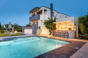 a house with a swimming pool in front of a house at The Infinities - Premium Villa Alexandros in Kos