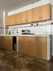 an empty kitchen with wooden cabinets and a sink at Casa Totora in Huanchaco +24 photos
