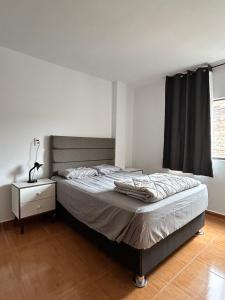 a bedroom with a bed and a dresser and a window at Casa Totora in Huanchaco