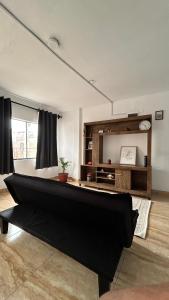 a living room with a black couch in a room at Casa Totora in Huanchaco