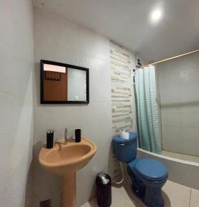 a bathroom with a sink and a toilet and a mirror at Casa Totora in Huanchaco