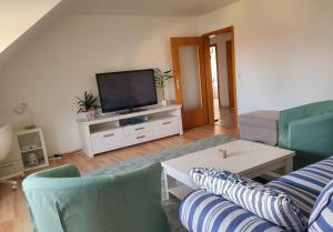 a living room with a couch and a tv at Ferienwohnung Erdmännchen in Erfurt +9 photos