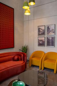 a living room with orange and yellow chairs and a table at Cyrus One By Trivelles in Islamabad +29 photos