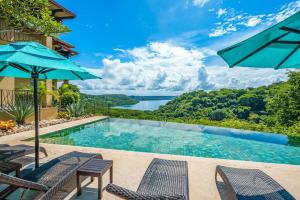 a swimming pool with chairs and a view of a lake at Las Terrazas 7 Peninsula Papagayo in Nacascolo